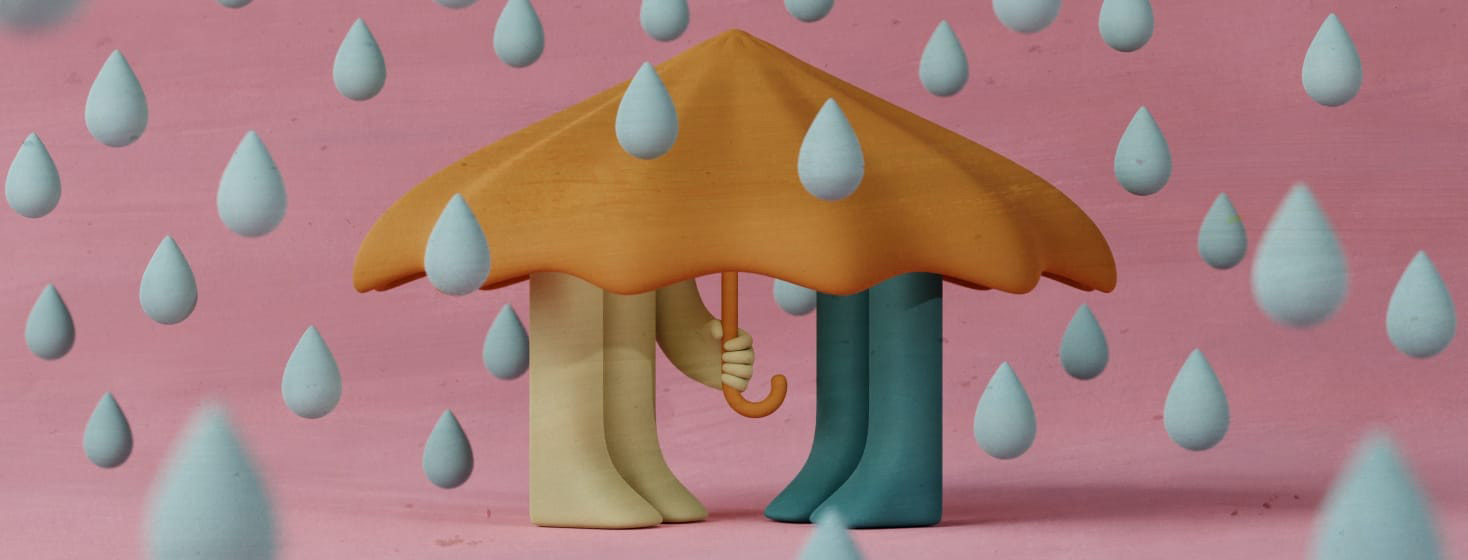 a pair of people huddled together under an umbrella in the rain