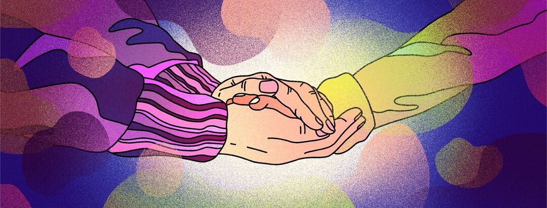 One person's hands reach out to hold another's in a gesture of comfort.